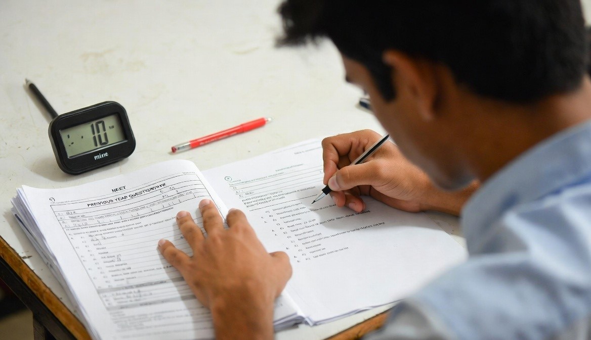 Student practicing importance of solving previous year papers in April for NEET with timer and question sheets